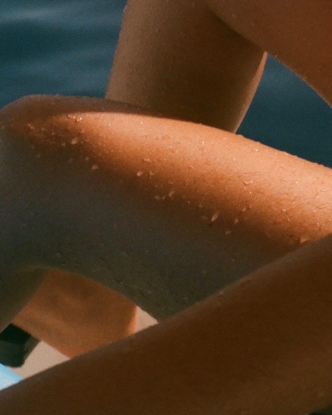 Film photo of women on the edge of water. her legs cropped in. Photographer: Christopher Hendriks